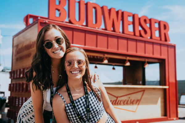 Girls pose in front of Budweiser box activation copy